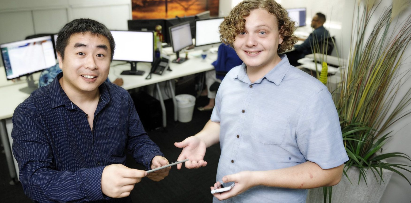 Two men are standing next to each other in an office.