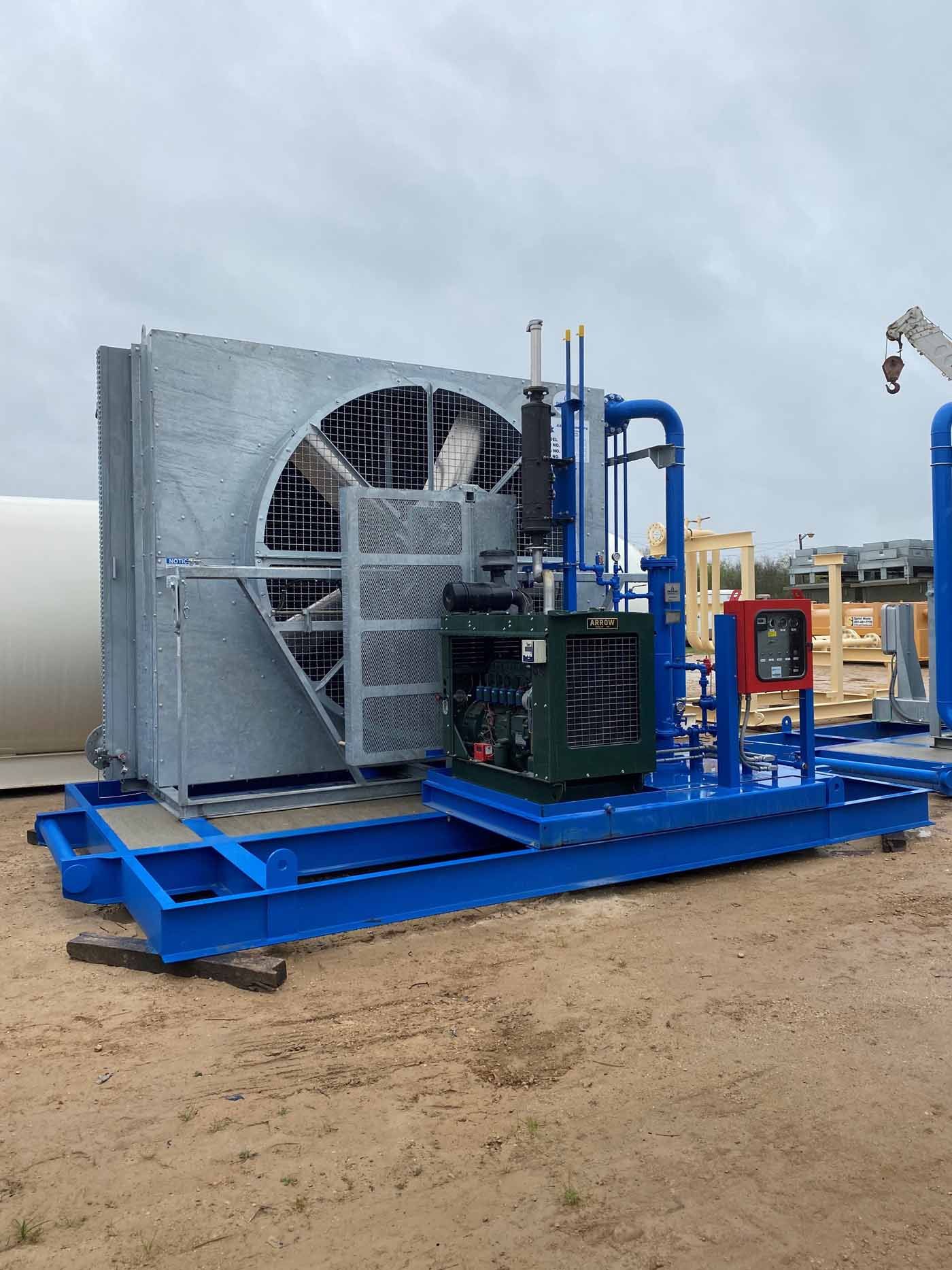 A large fan is sitting on top of a blue platform in the dirt.