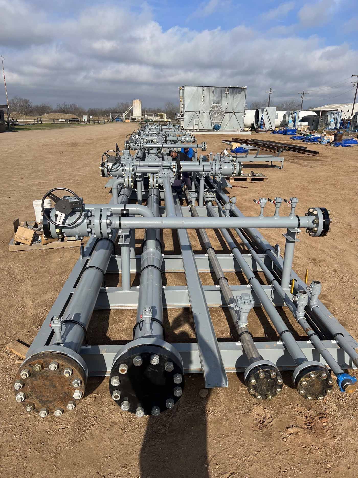 A row of pipes sitting on top of a dirt field.