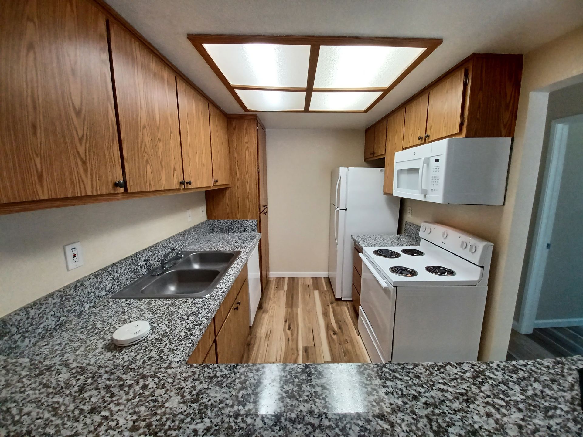 A kitchen with granite counter tops and wooden cabinets