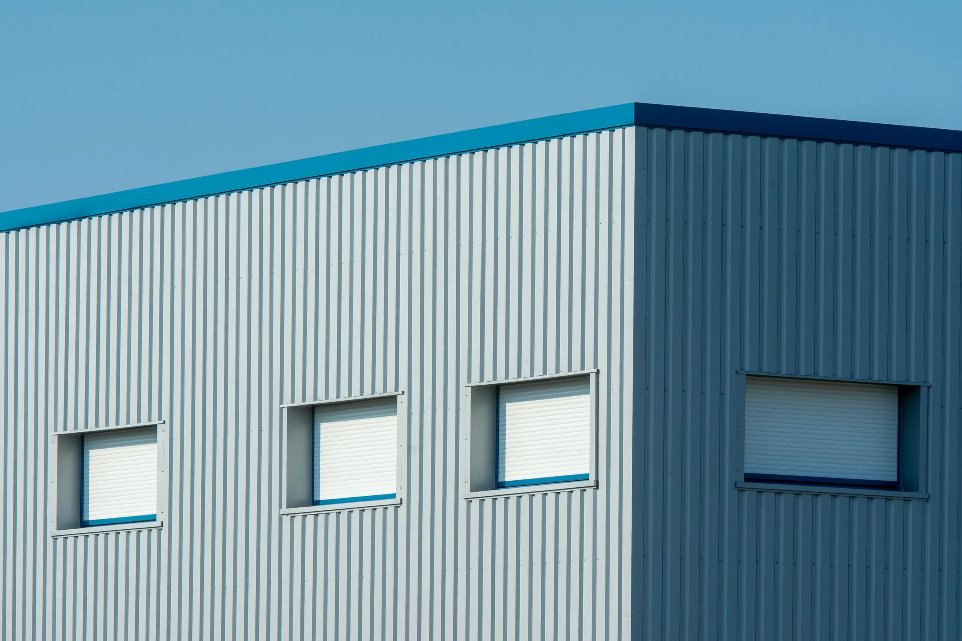 Aerial view of a gray-roofed house with a concrete driveway and green lawn.