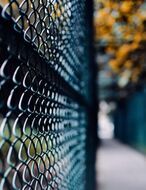 Close-up photograph of black chain-link fencing at a park