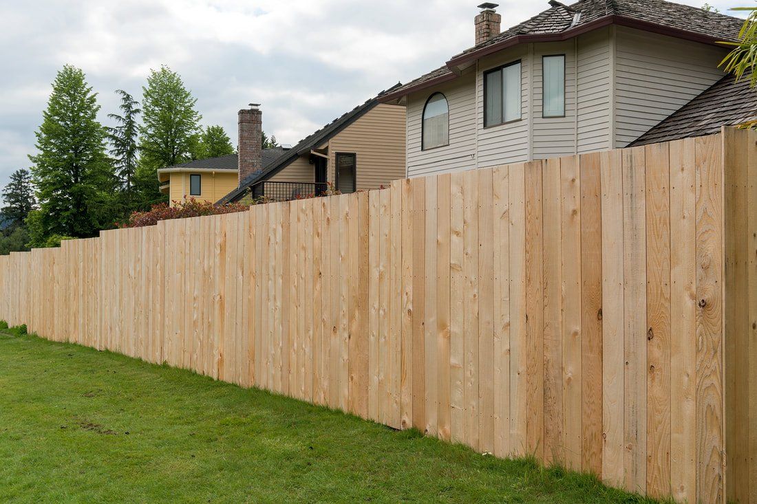 A wood privacy fence enclosing the backyard of a large two story home in Columbus Ohio.