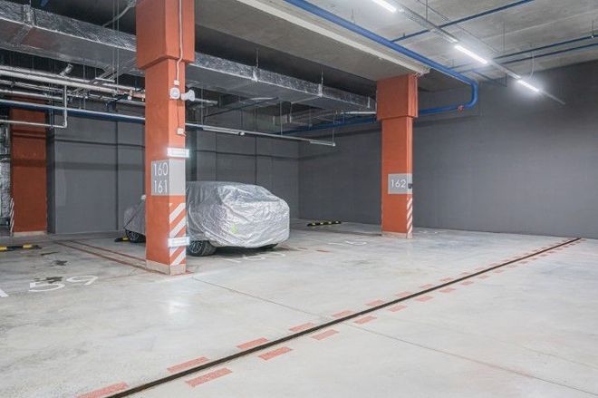 A car is parked in a covered parking garage.