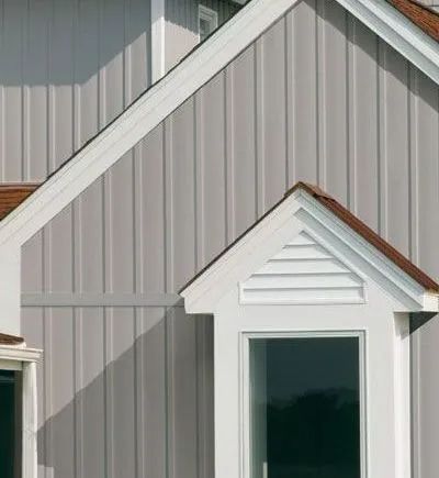 a close up of a house's siding with a window and a roof
