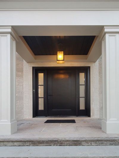 the front door of a house with a black door and a light on the ceiling