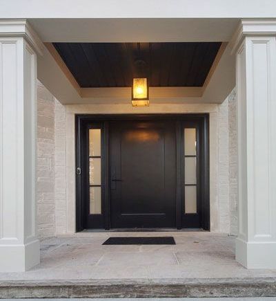 a house with a black front door and a lantern hanging from the ceiling