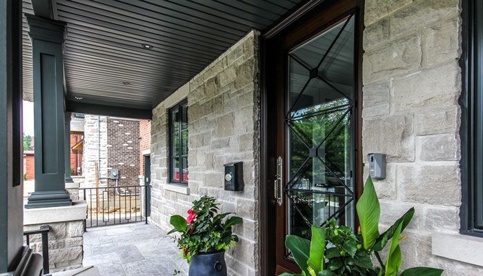 the front porch of a brick house with a wooden door