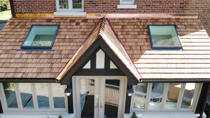 an aerial view of a house with a cedar roof and skylights