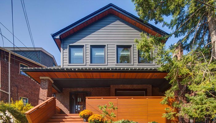 the front of a house with a wooden porch and stairs