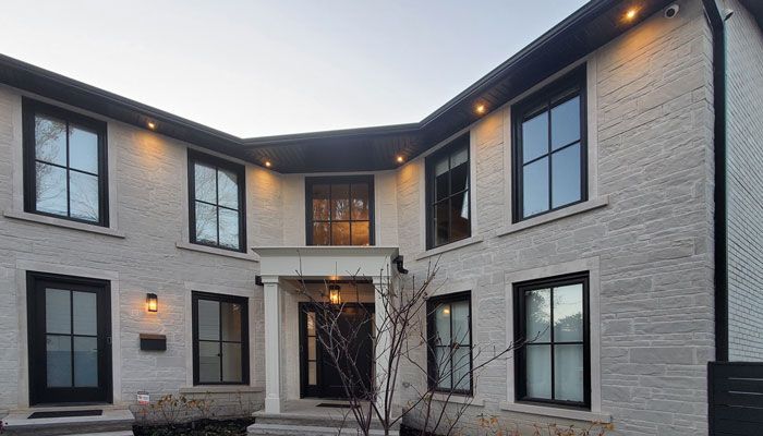 a large white brick house with black windows and black doors