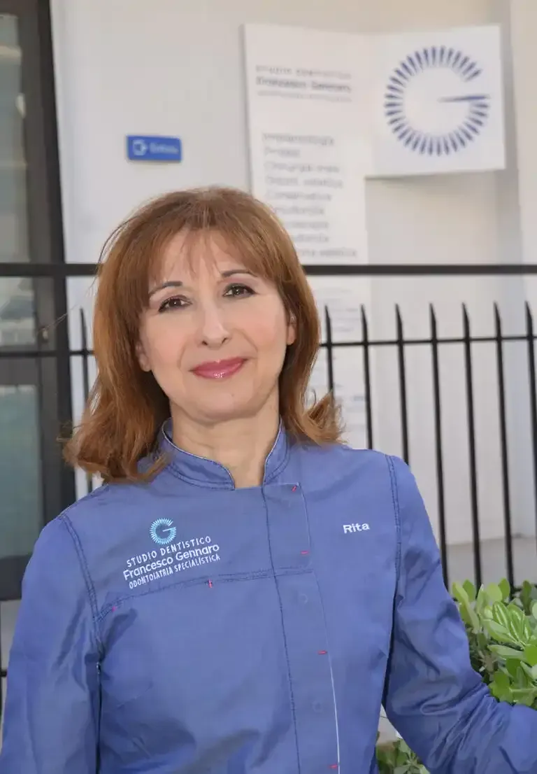 Donna con giacca da chef blu in piedi all'aperto davanti all'insegna di un edificio