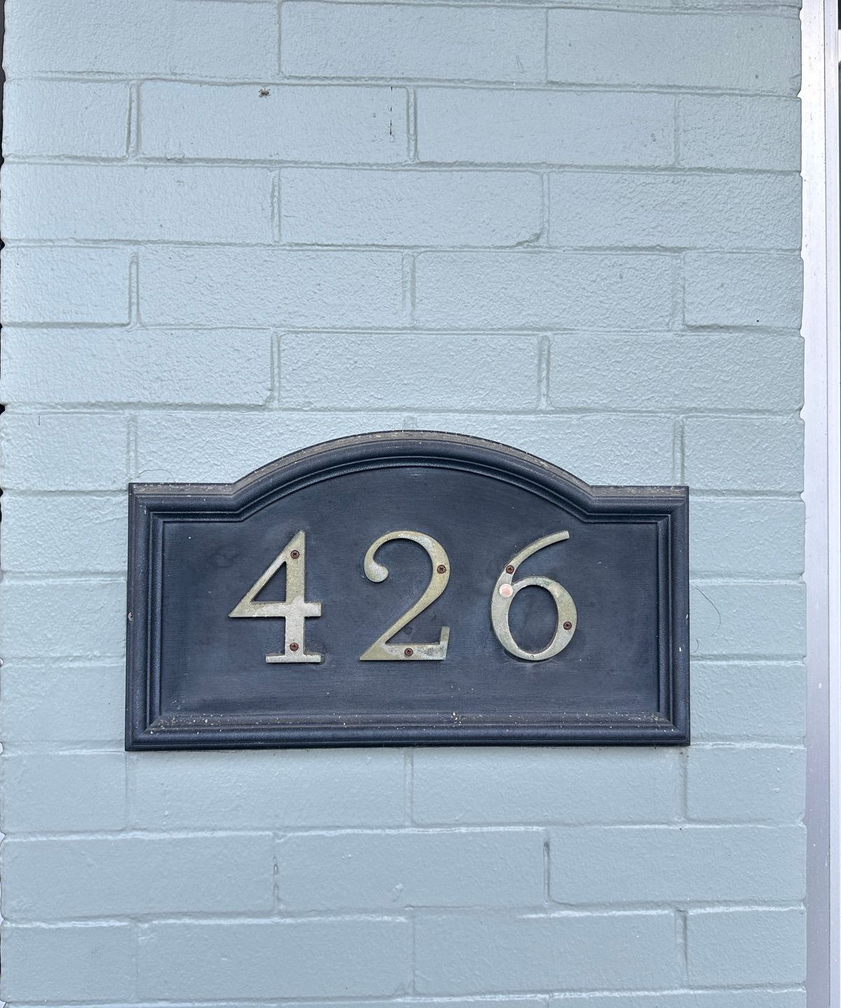 A sign on a brick wall shows the number 427