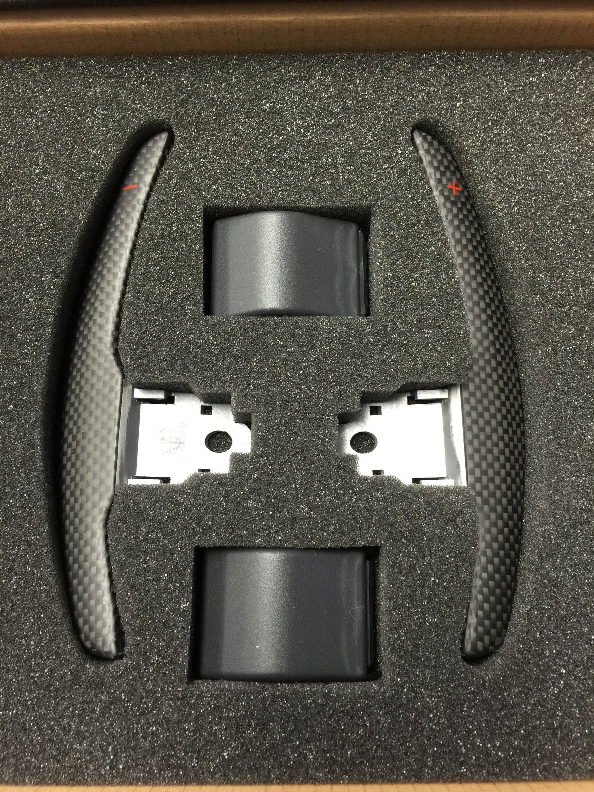 A pair of carbon fiber paddle shifters in a box.