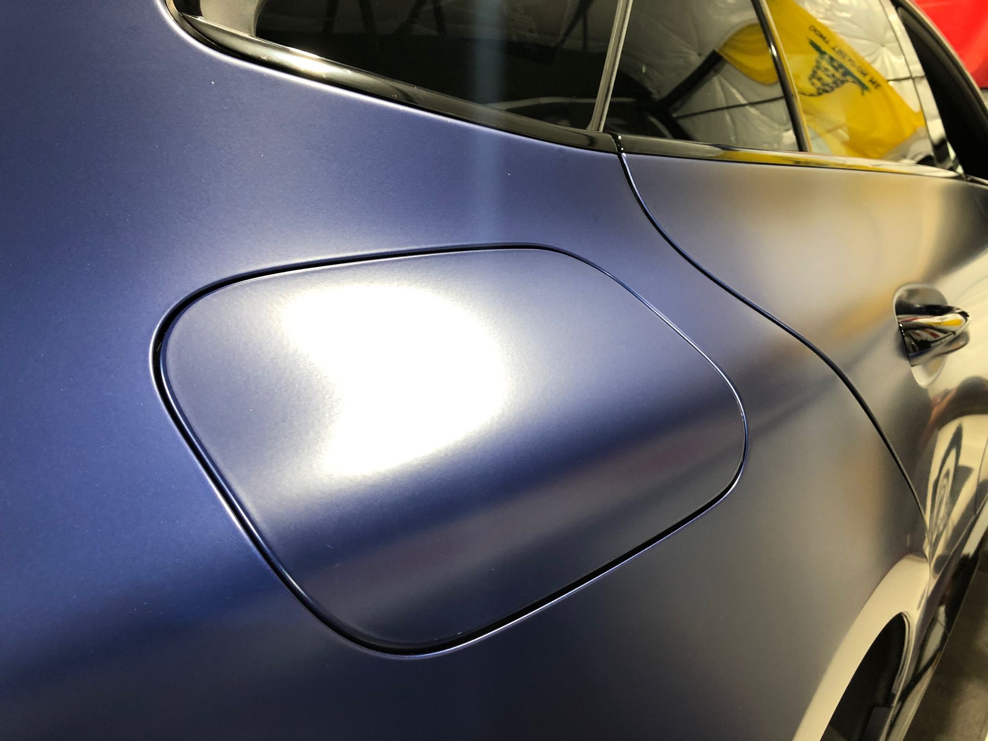 A close up of a blue car with a fuel cap on it.