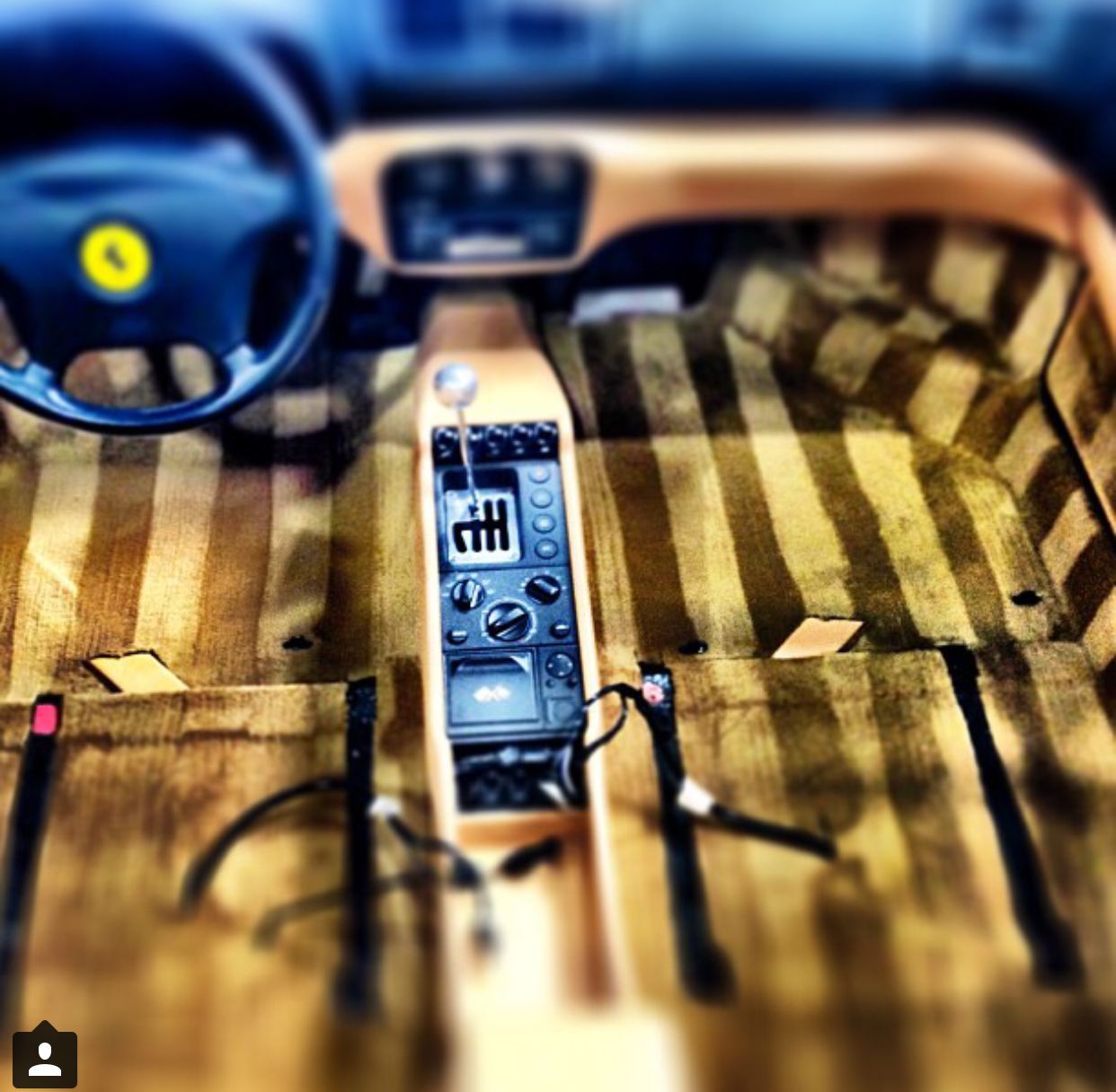 A picture of the interior of a car with a yellow ferrari logo on the steering wheel