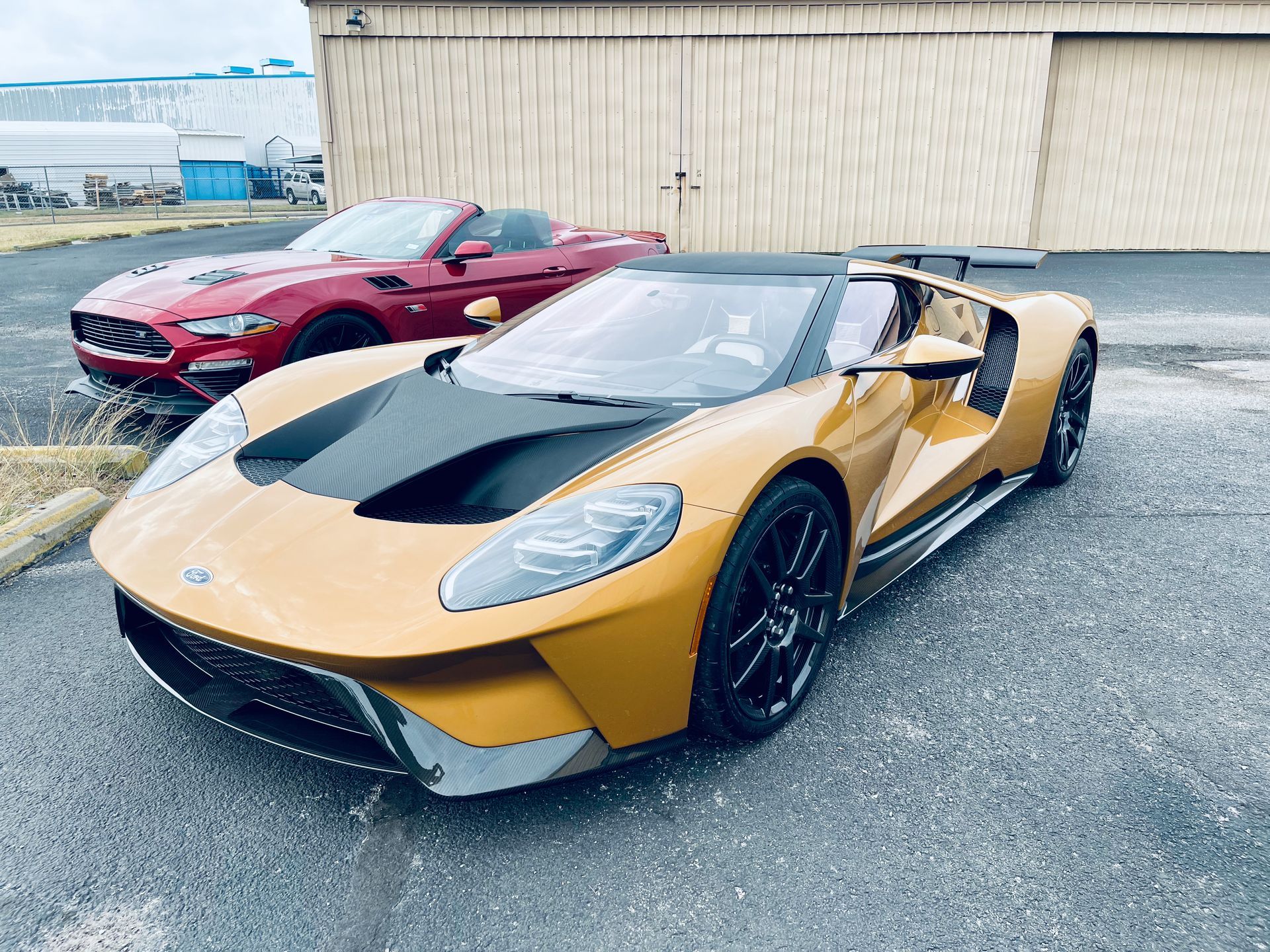 Two sports cars are parked next to each other in a parking lot.