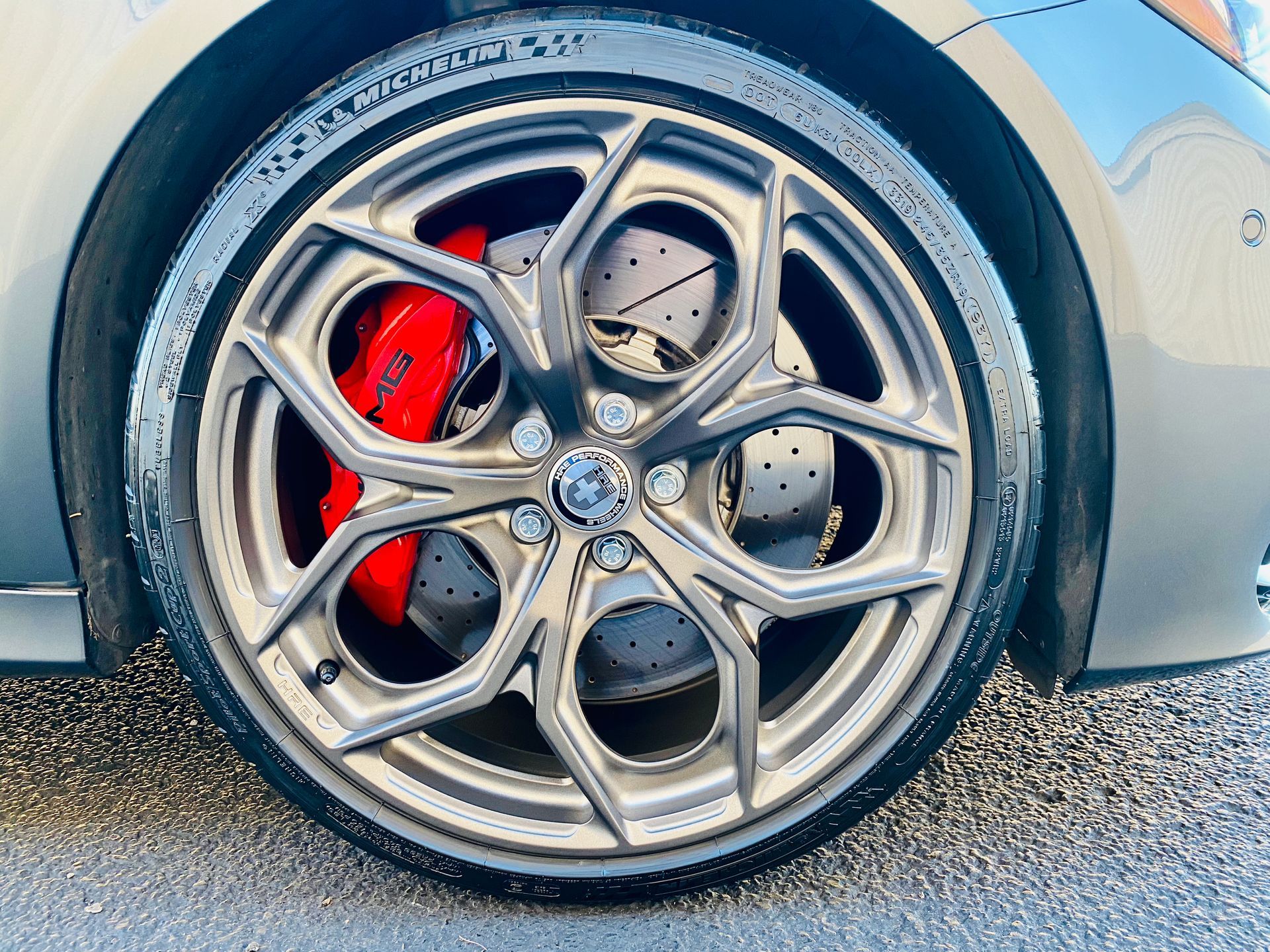 A close up of a car wheel with red brake calipers