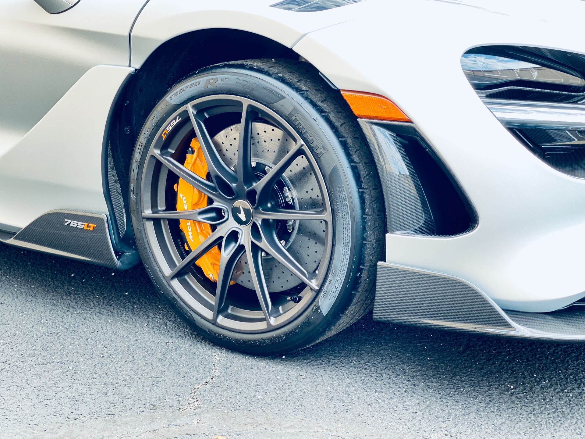 A close up of a car wheel with a yellow brake caliper