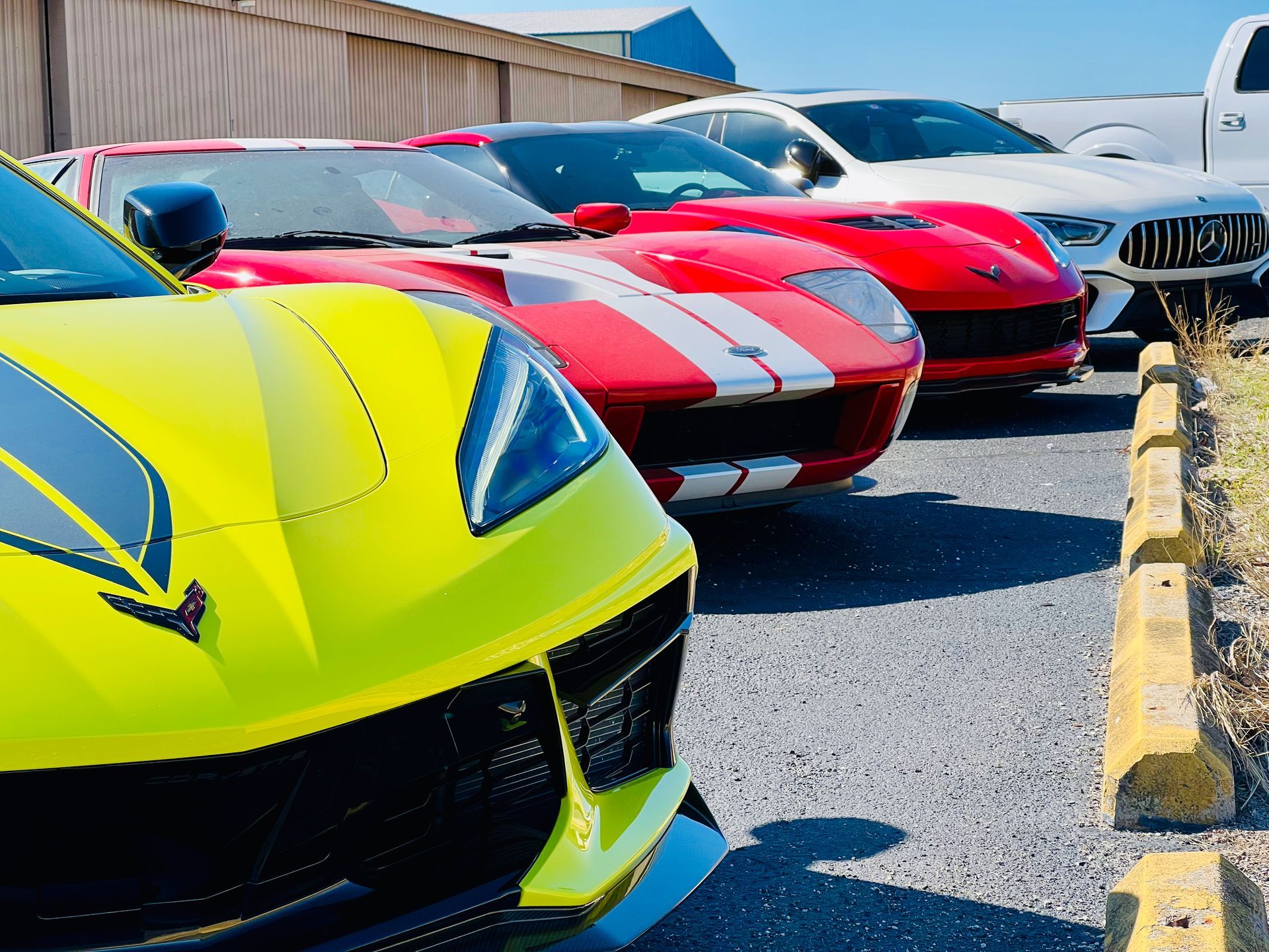 A row of sports cars are parked next to each other in a parking lot.