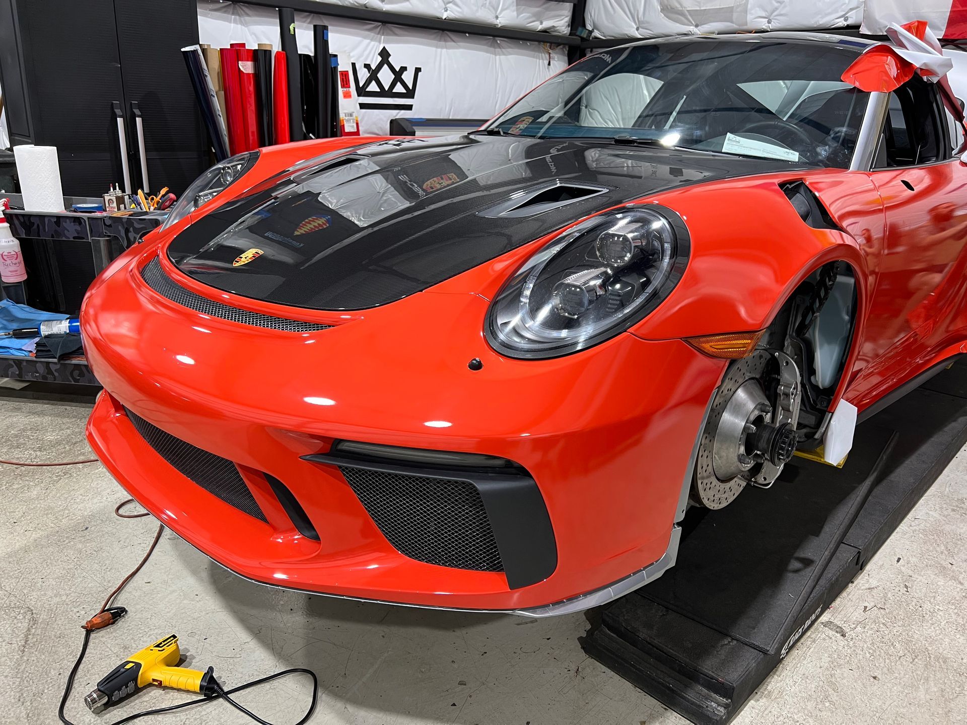 A red porsche 911 gt3 rs is sitting on a ramp in a garage.