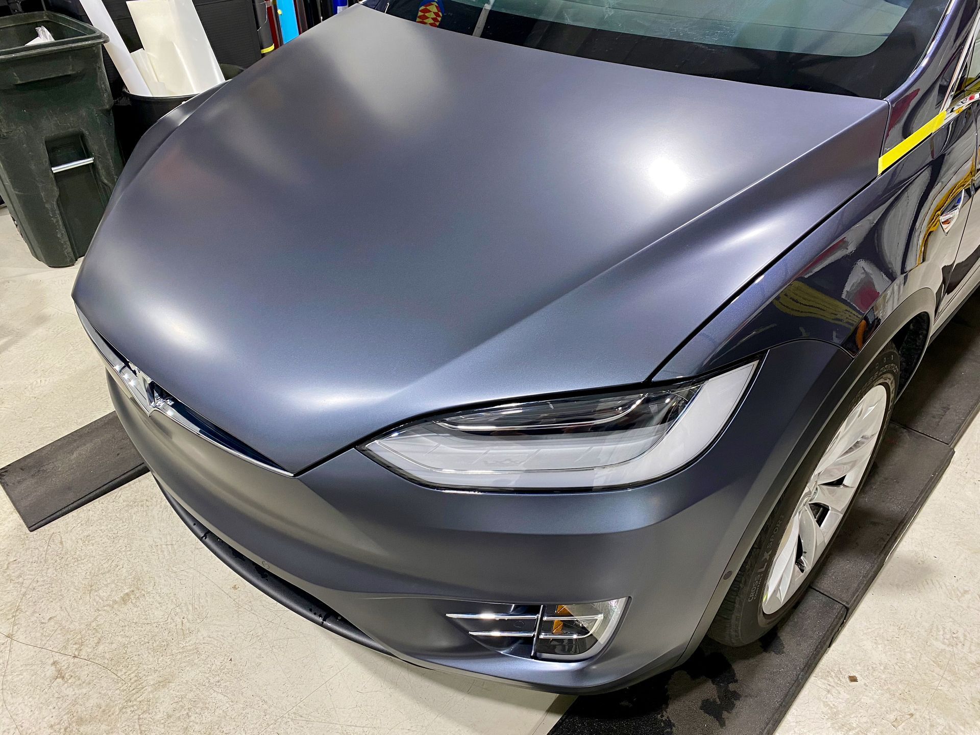 A gray tesla model s is parked in a parking lot.