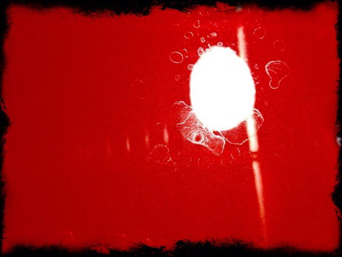 a close up of a red car door with white spots on it .