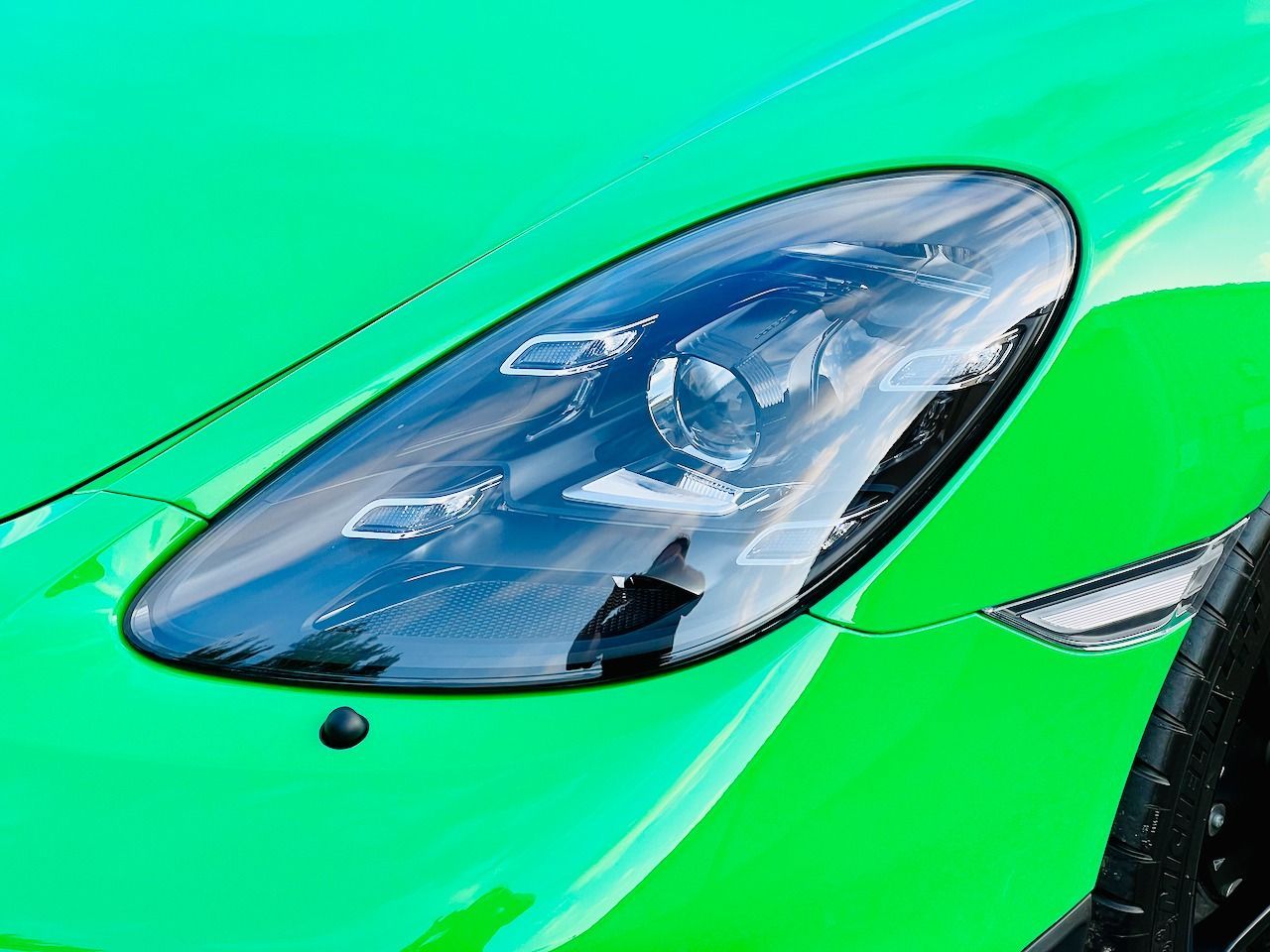 A close up of a green car 's headlight