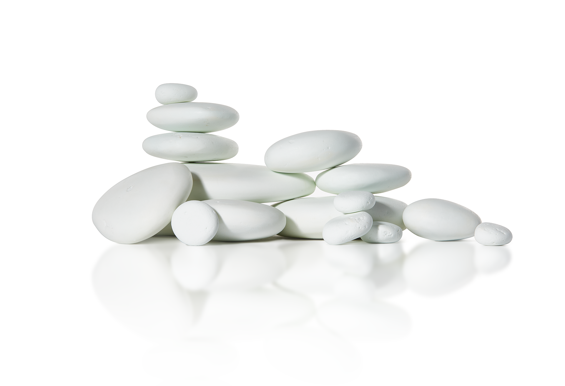 A pile of white rocks stacked on top of each other on a white surface.