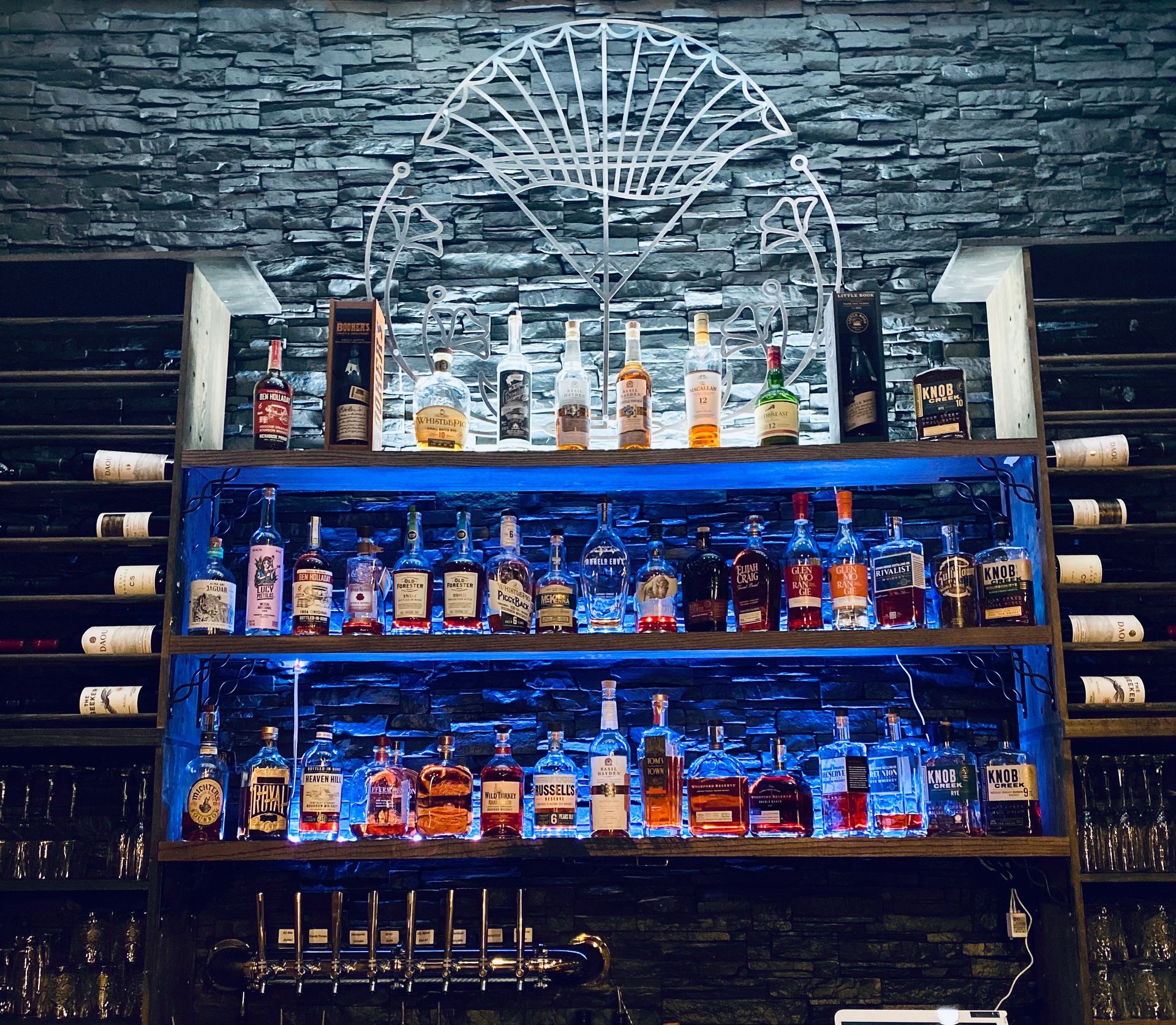A bar with a lot of bottles of alcohol on shelves