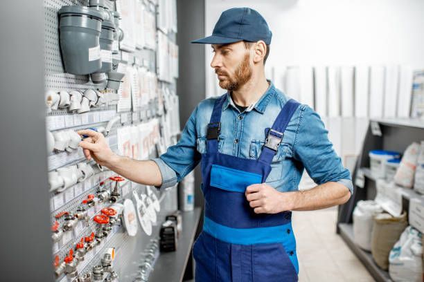 Person in a blue overalls and a hat looking at a wall