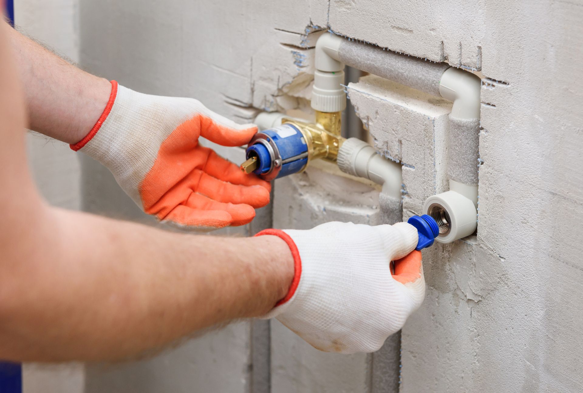 A man is fixing a pipe in a bathroom.