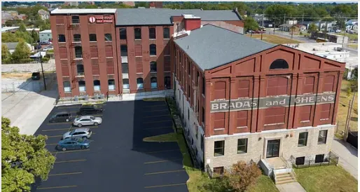 Brick industrial buildings with a parking lot.  The building on the right has 