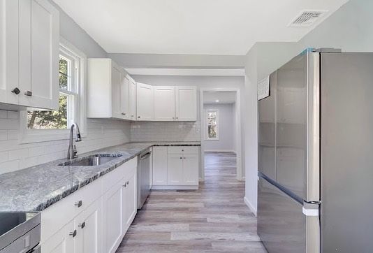 A group of men are working on a roof of a house.