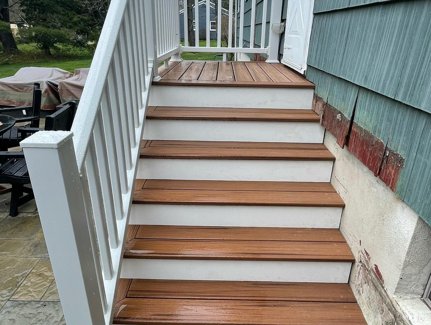 A hallway with hardwood floors and stairs leading to a kitchen.