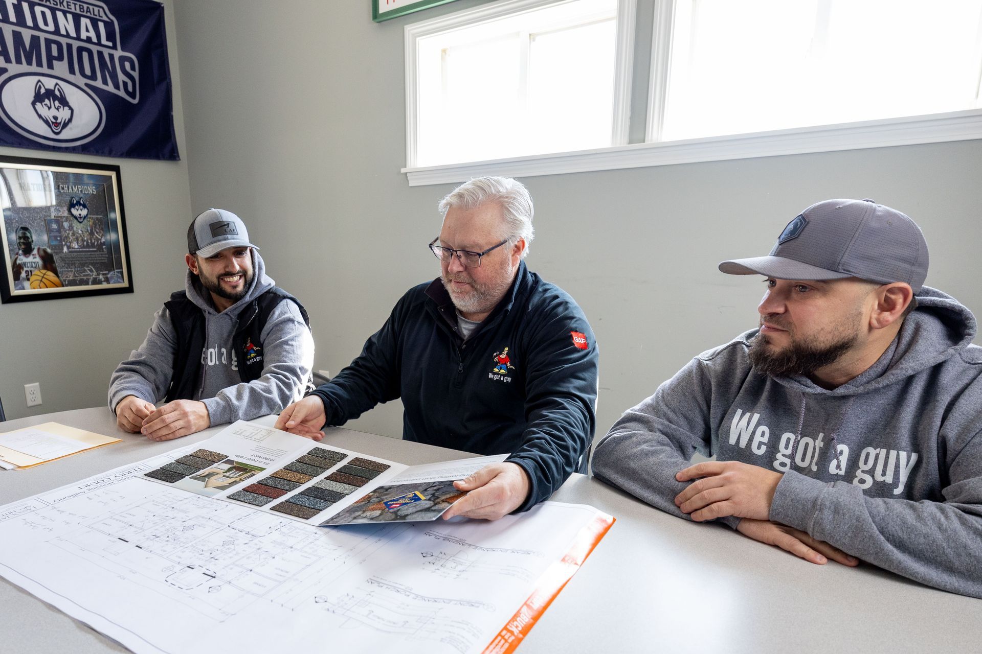 A group of people are sitting around a table in a room.