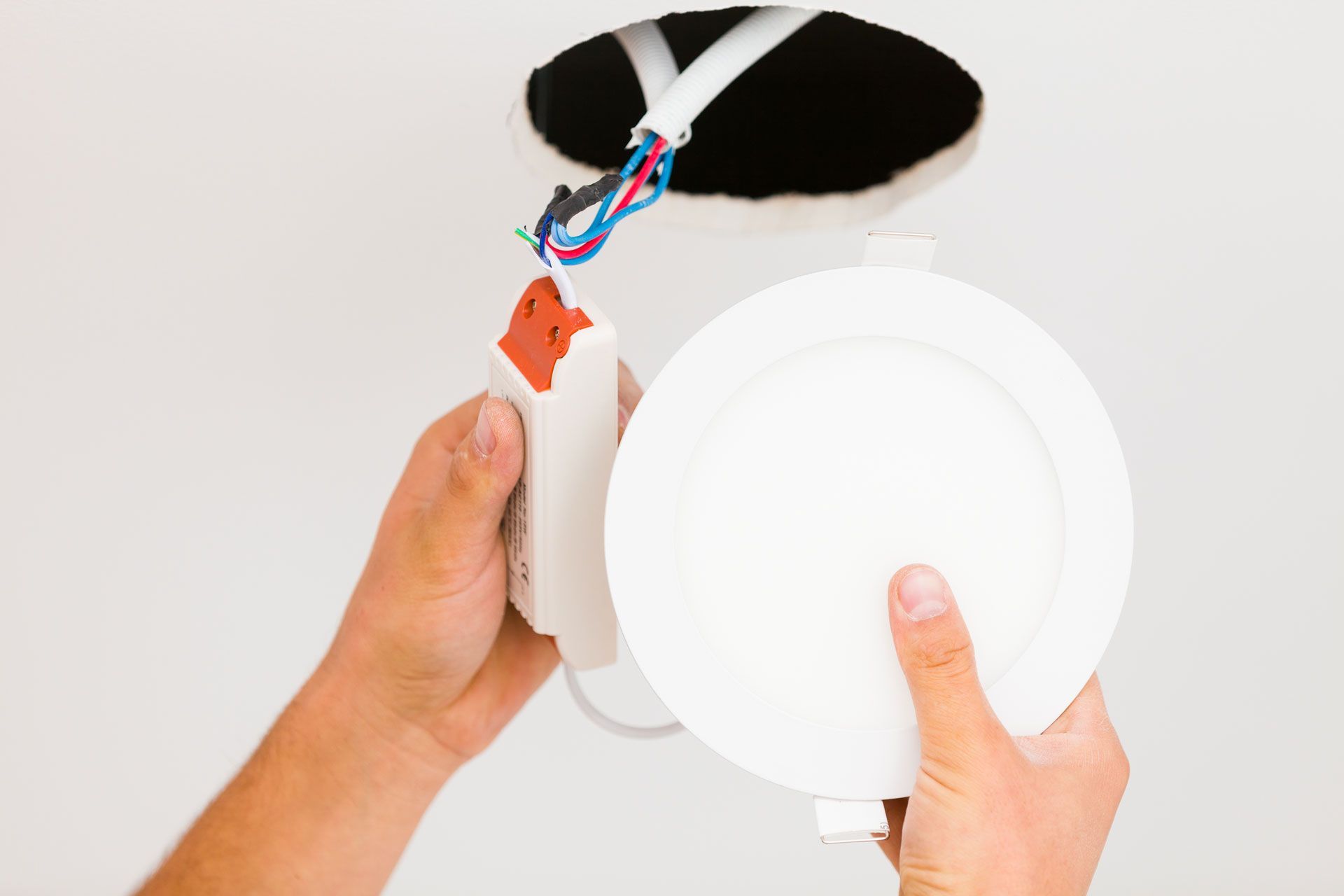 A white house with black shutters and a hose in front of it