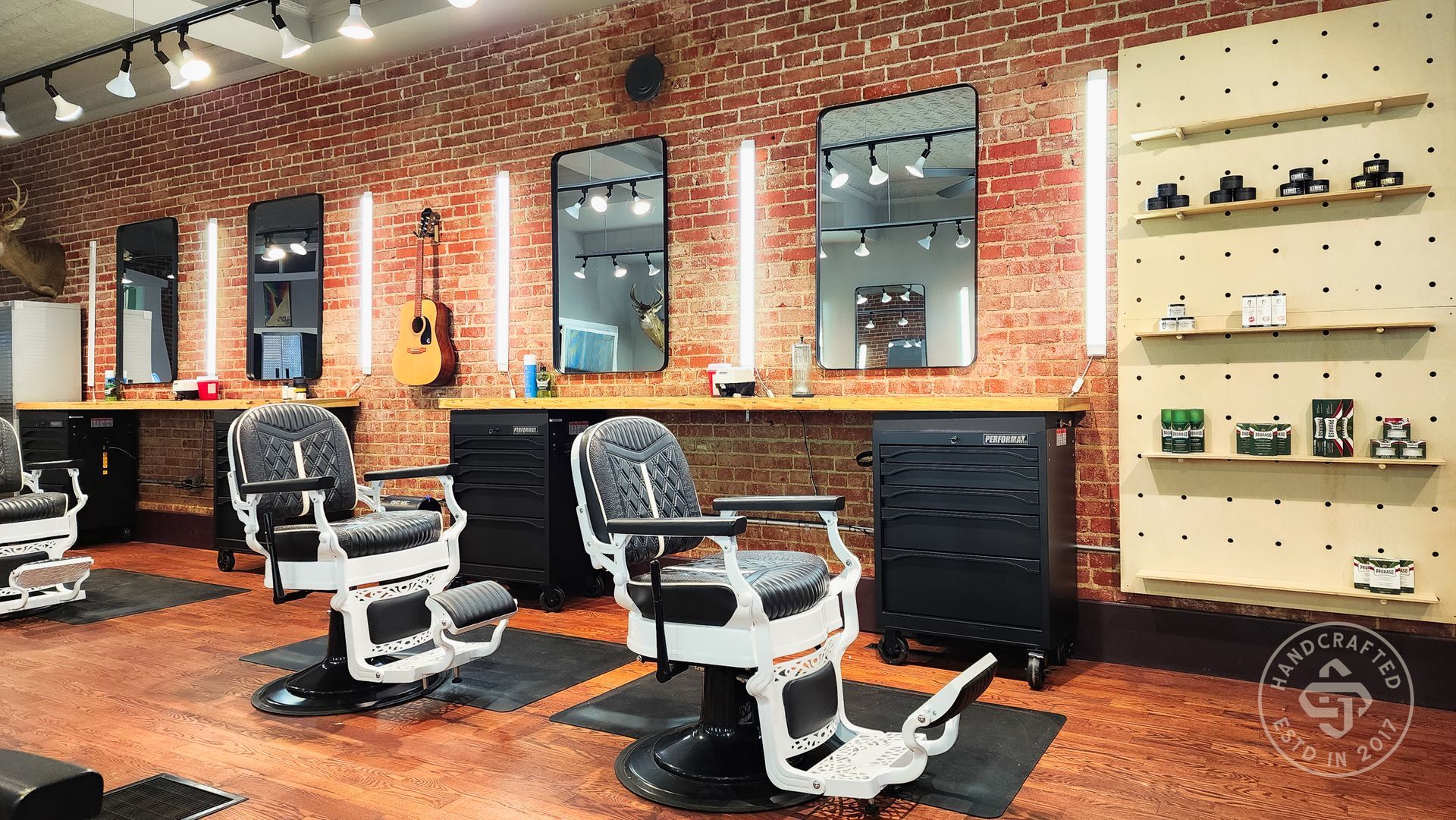 A barber shop with a brick wall and barber chairs.