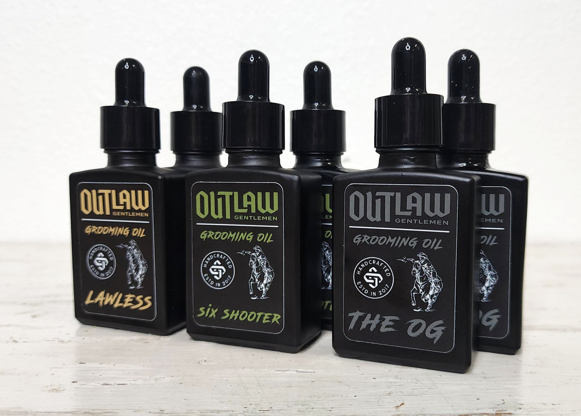 A group of bottles of outlaw oil are sitting on a table.