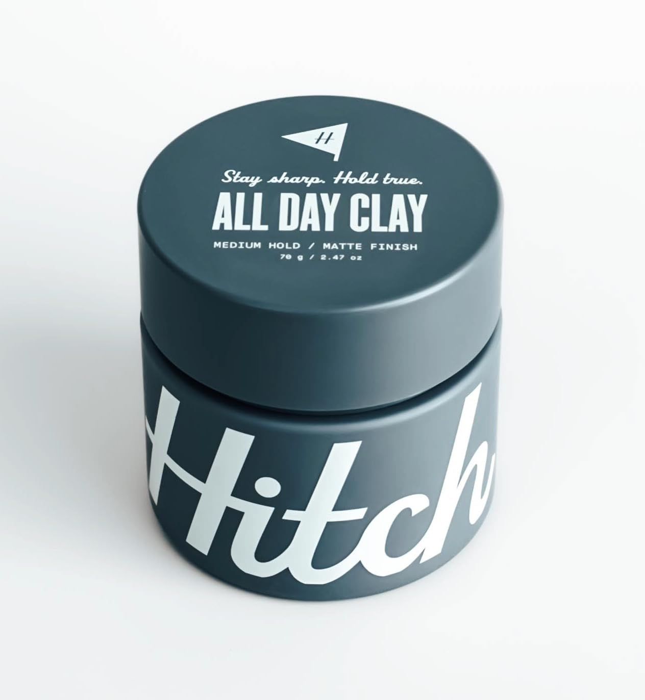 A jar of hitch all day clay on a white surface