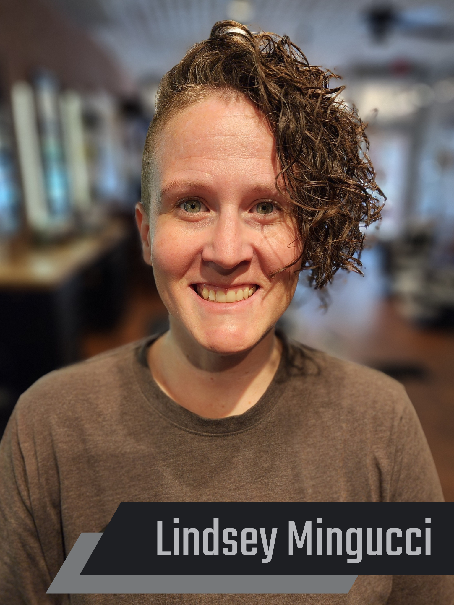 Woman with curly hair smiling in a salon. Text reads