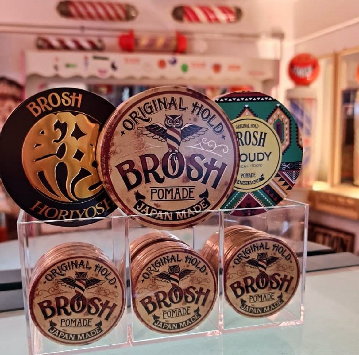 Three containers of brosh pomade are sitting on a table