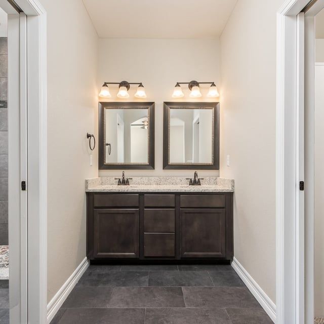 A bathroom with two sinks and two mirrors