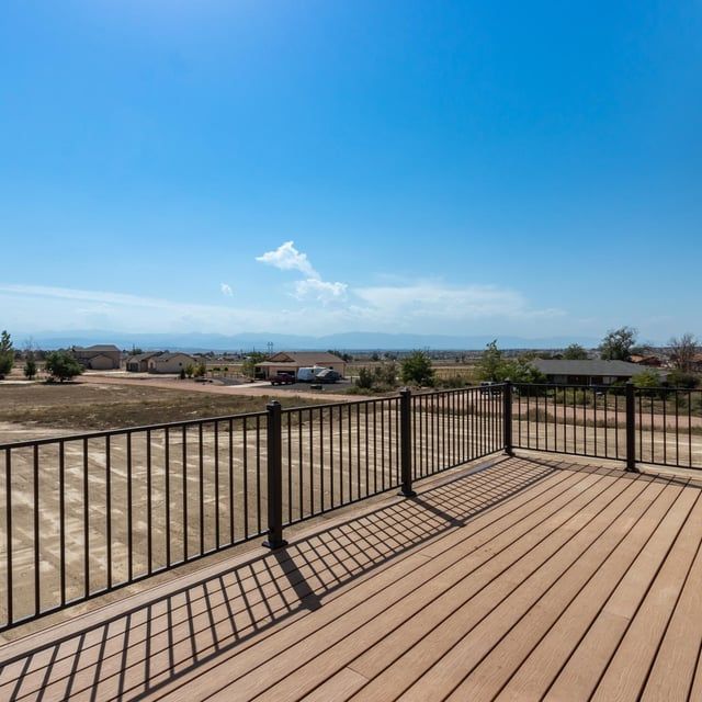 A deck with a fence and a view of the ocean