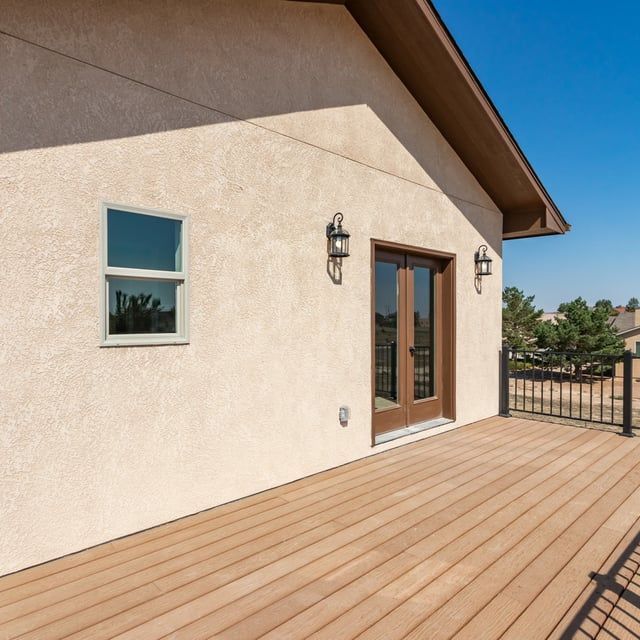 A house with a wooden deck in front of it