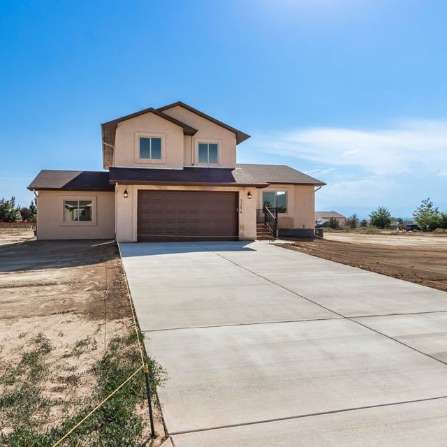 A house with a concrete driveway leading to it