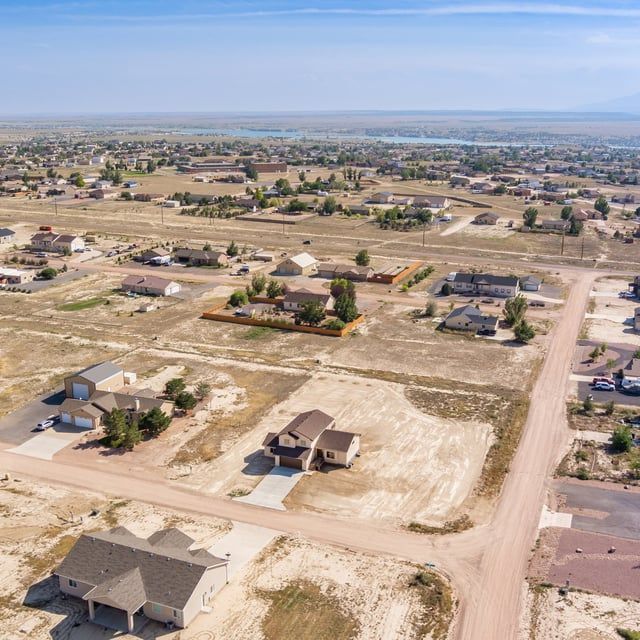 An aerial view of a residential area with houses and a dirt road.