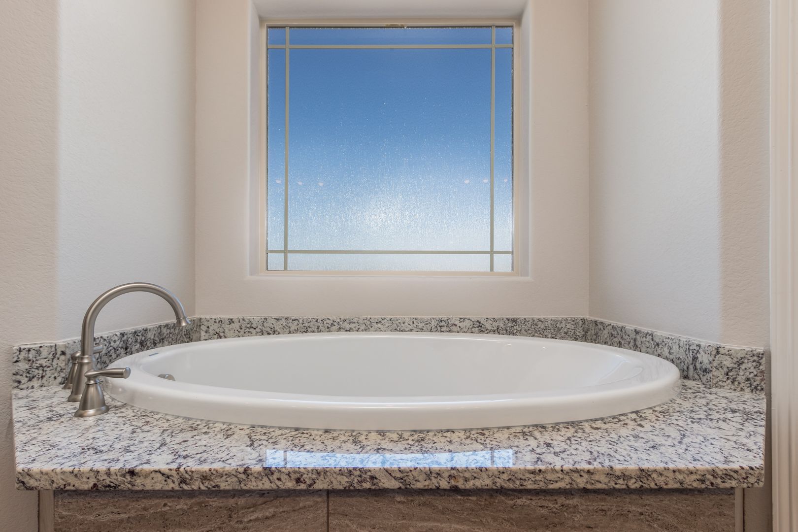 A bathroom with a jacuzzi tub and a window.