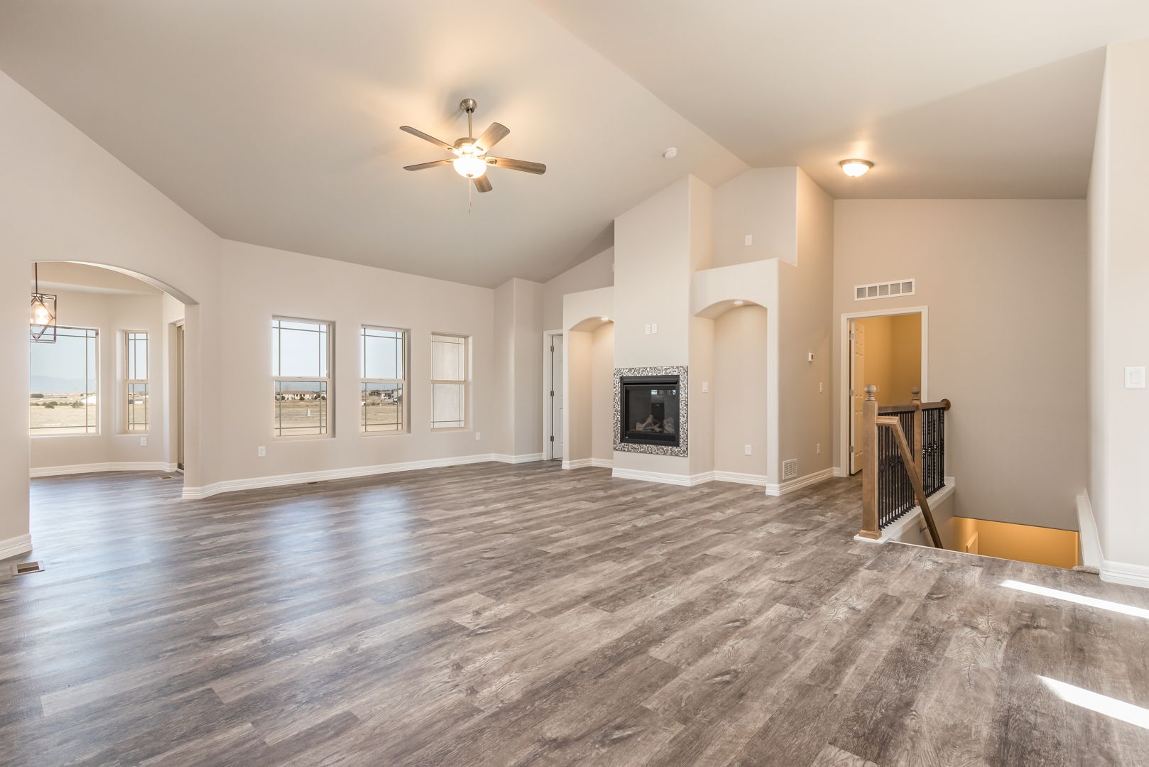 A large empty living room with hardwood floors and a fireplace.