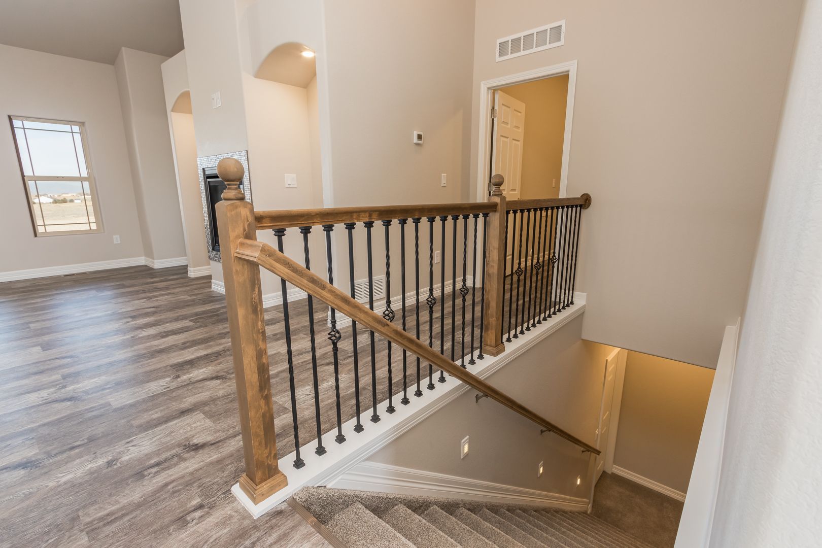 A staircase with a wooden railing leading up to the second floor of a house.